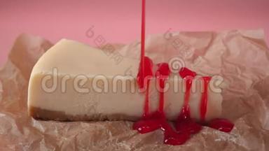用红色果<strong>酱</strong>装饰在食品<strong>包装</strong>纸上的奶酪蛋糕。 框架。 孤立于粉红色